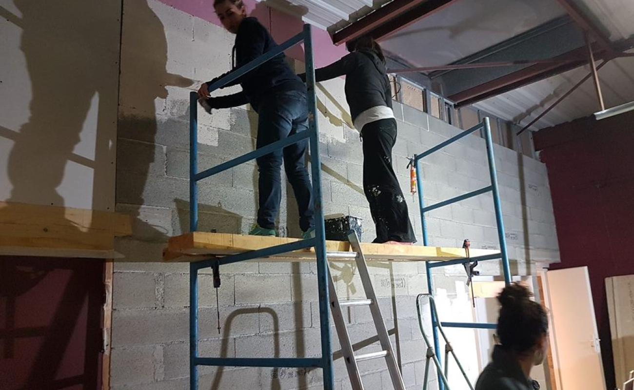 3 femmes peignent un mur